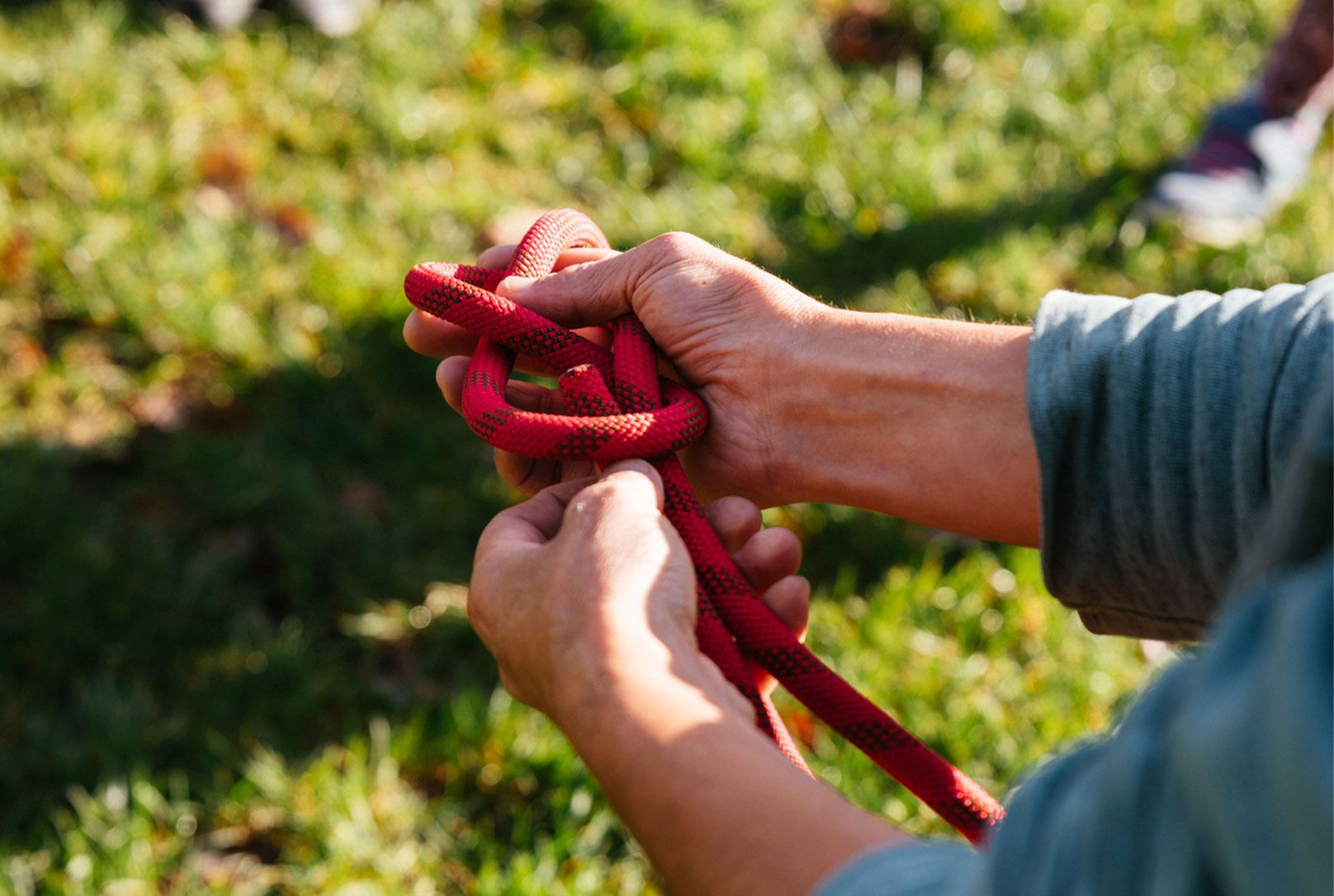 Hände die Karabiner mit Seil halten